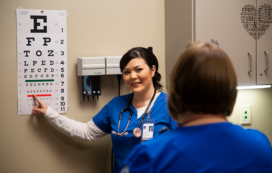 A medical assistant student doing an eye exam on a student patient