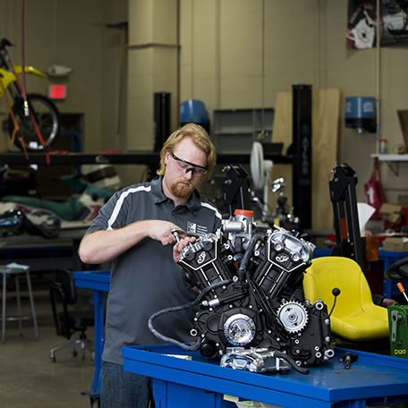 A student working on a motorcycle in the power sports lab