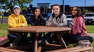 Students sitting on outdoor table at campus