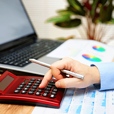 CLOSE UP OF HAND USING RED CALCULATOR