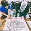 2 students looking at electrical map in the lab