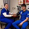 A medical assistant student checking blood pressure on a student patient