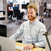 A happy male office worker making a phone call