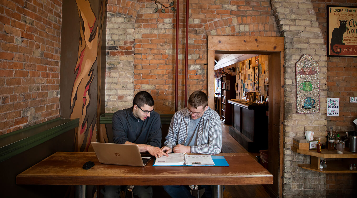 Two students working together in a cafe