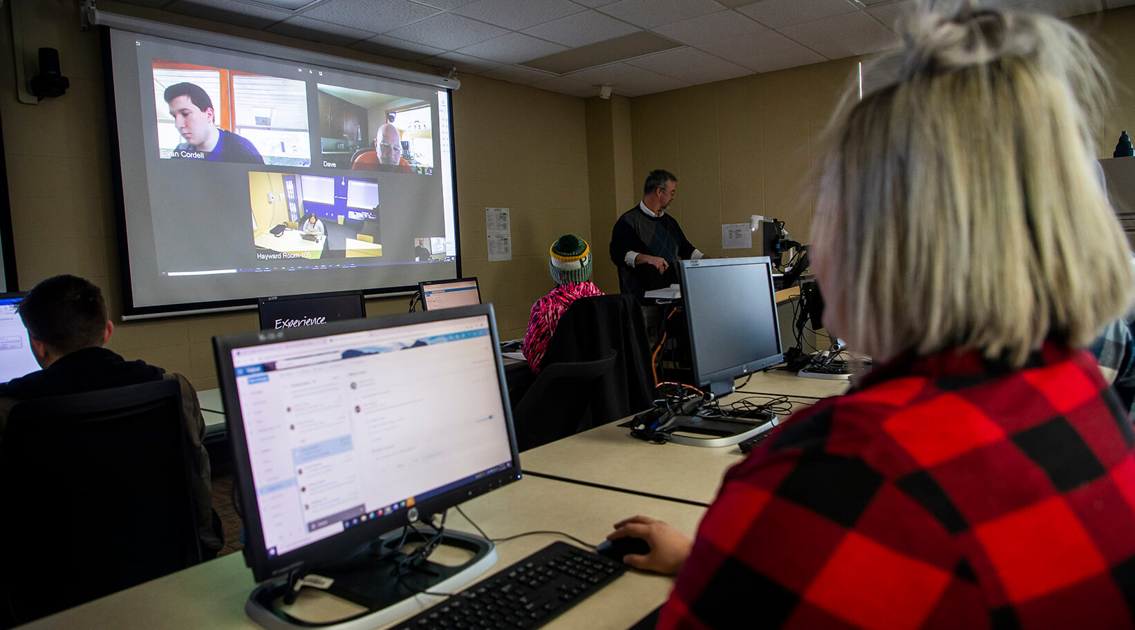 A student in a classroom with other students attending remotely