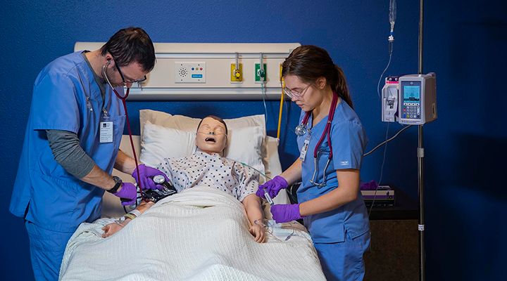 Two nursing student working together on a simulated patient