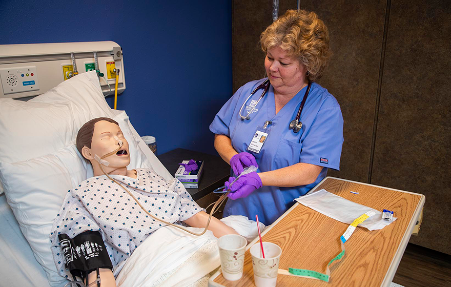 A student nurse practicing on a simulated patient