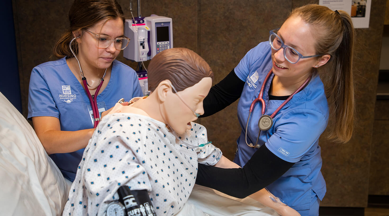 Two students working with a simulated patient