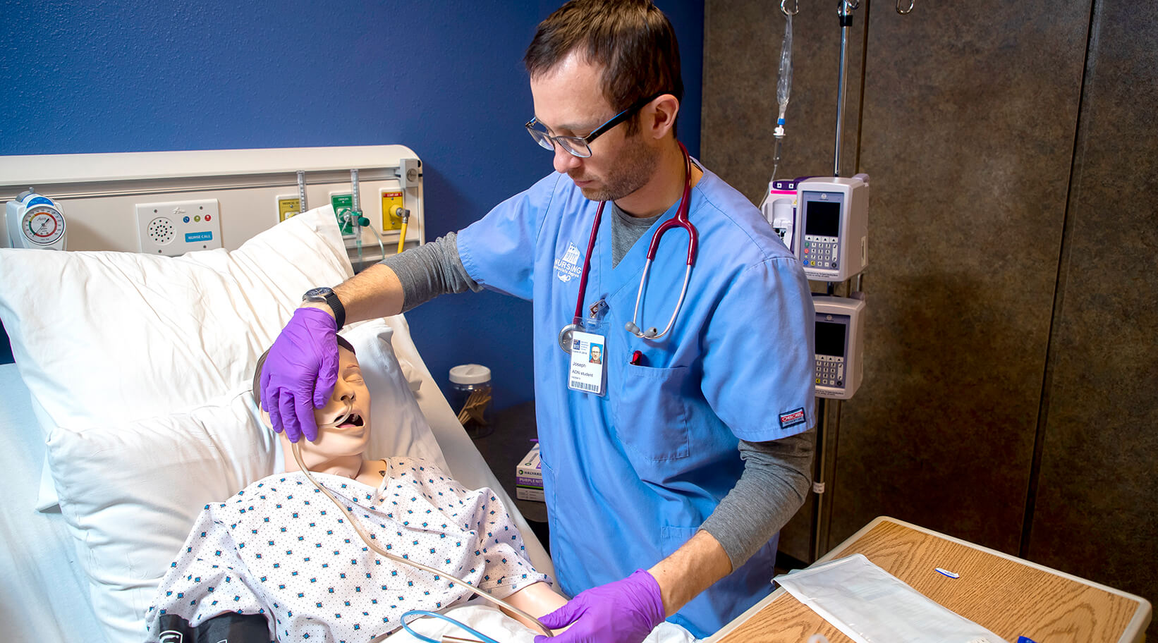 A nursing student working with a simulated patient