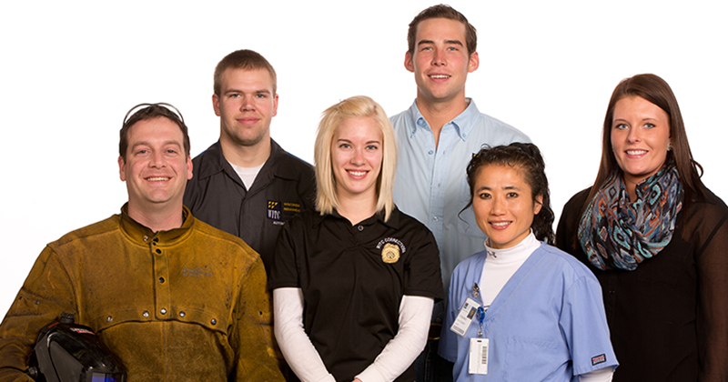 Students from various programs wearing their career outfits smile against a white background