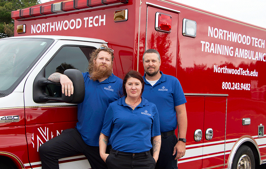 3 Advanced EMT students standing in front of Northwood Tech ambulance