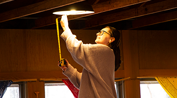 Hands on image of student measuring a lighting fixture