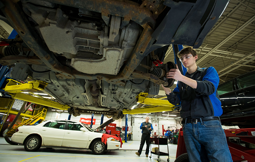 Nationally top-ranked vocational program. Automotive student repairing the brakes of a car in the automotive lab on campus