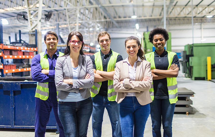 Portrait of staff at distribution warehouse smiling at camera