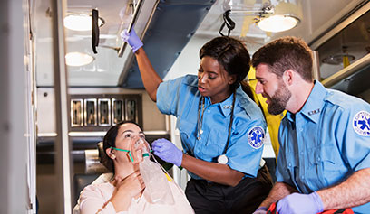 EMT-Paramedics in an ambulance treating a female patient