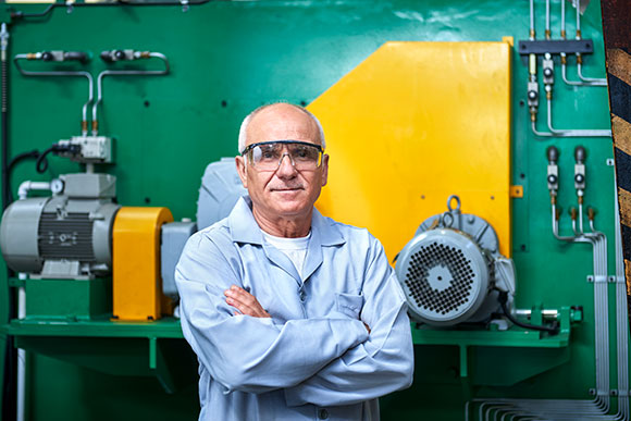 Older man posing for picture at work