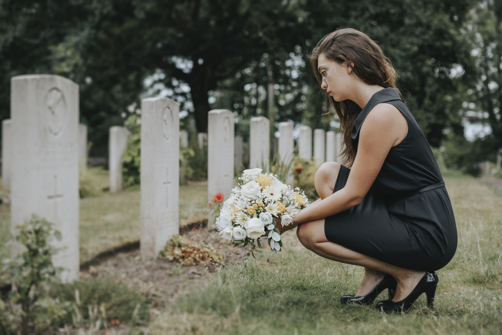Lady kneeling at grave site