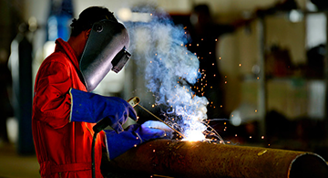 A professional in the industry welding a pipe