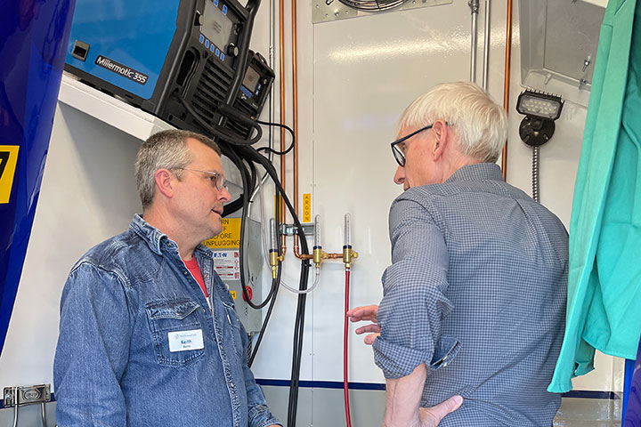 Governor Evers and instructor inside mobile welding lab explaining how the lab works