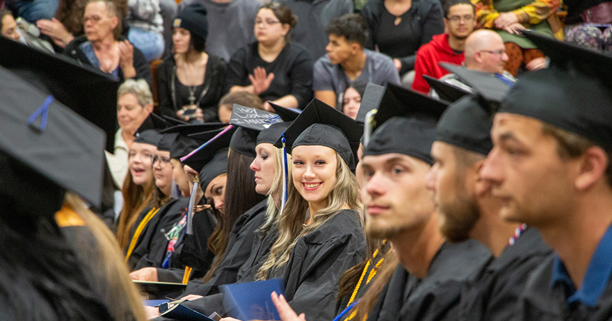 Northwood Tech students sitting at graduation in caps and gowns