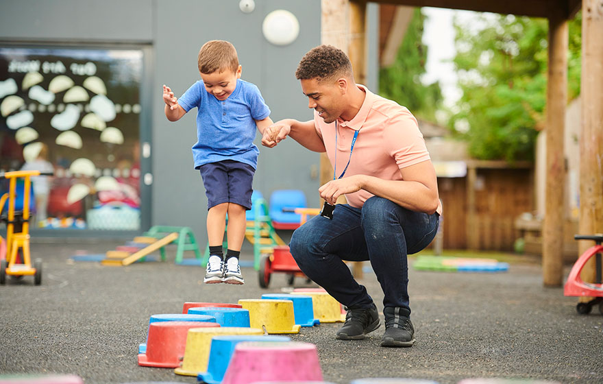 A child care worker playing with a preschool-aged kid