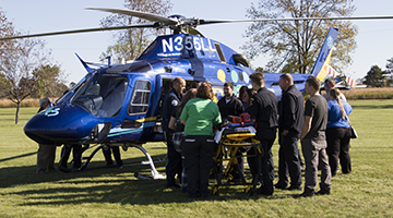 A group of students gathered around a helicopter