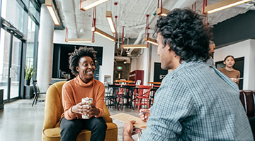 Two business professionals having coffee and a conversation