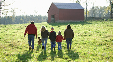 A family walking together by a barn