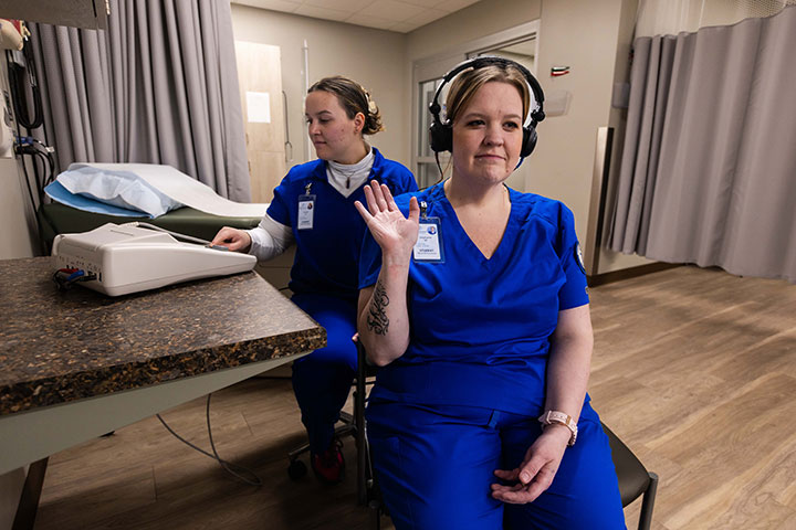 Medical Assistant student practicing administering hearing test with another student