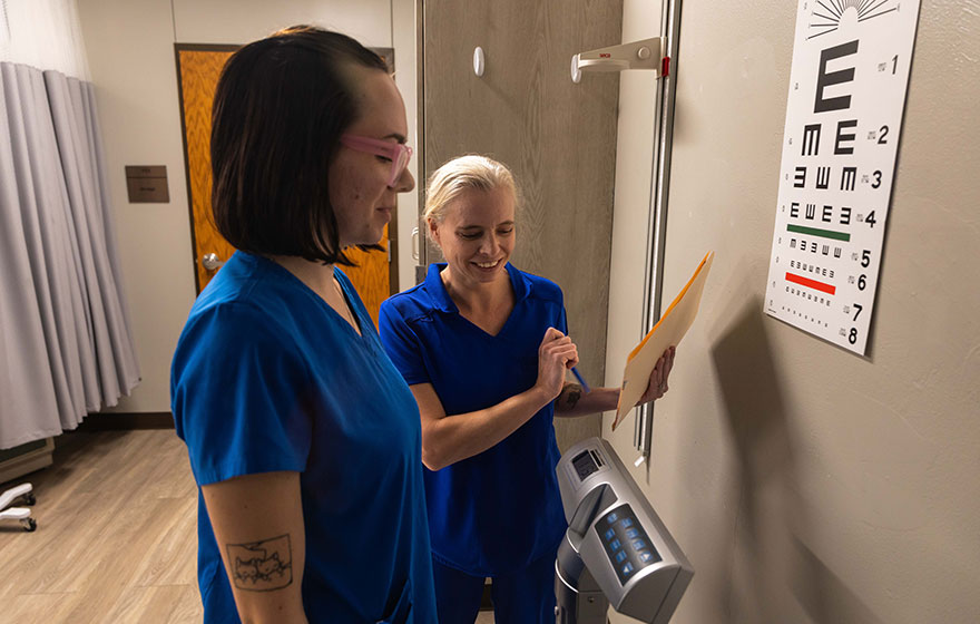 Medical Assistant student checking the weight of a student patient