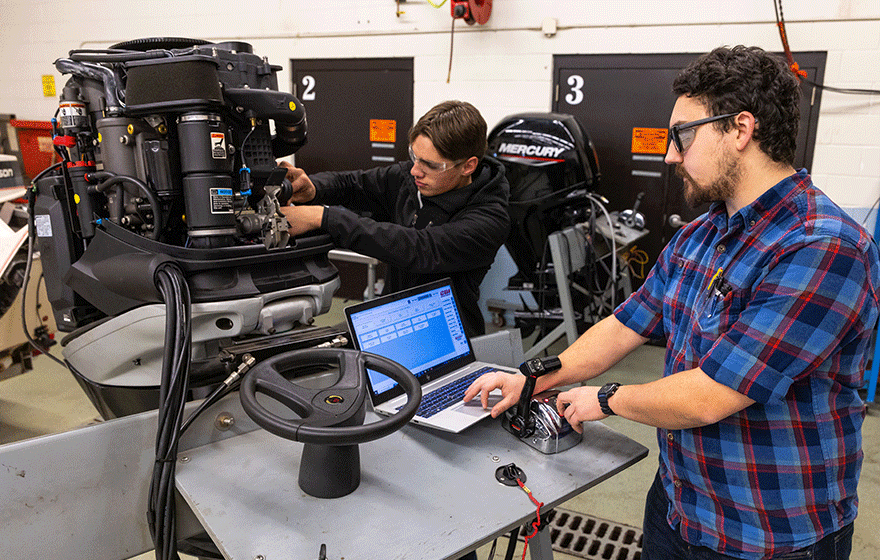 Marine repair students working on motor in the marine repair lab