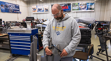 A marine repair student working in the marine repair lab