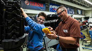 Marine repair student and instructor in lab