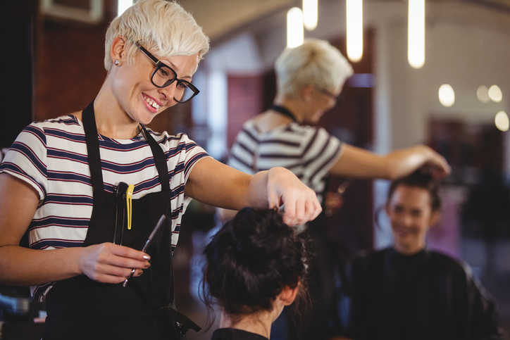 A cosmetologist working on a client