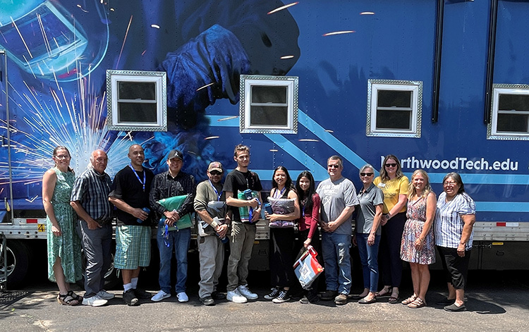 Graduates and Northwood Tech staff stand in front of the welding trailer during the graduation ceremony at St. Croix