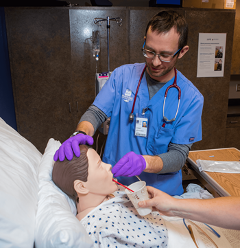 Male student works with simulation equipment in the Nursing program