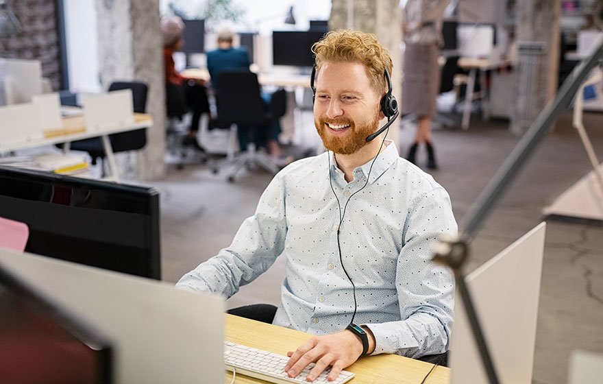 A happy male office worker making a phone call