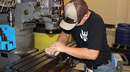 A student operating a CNC machine