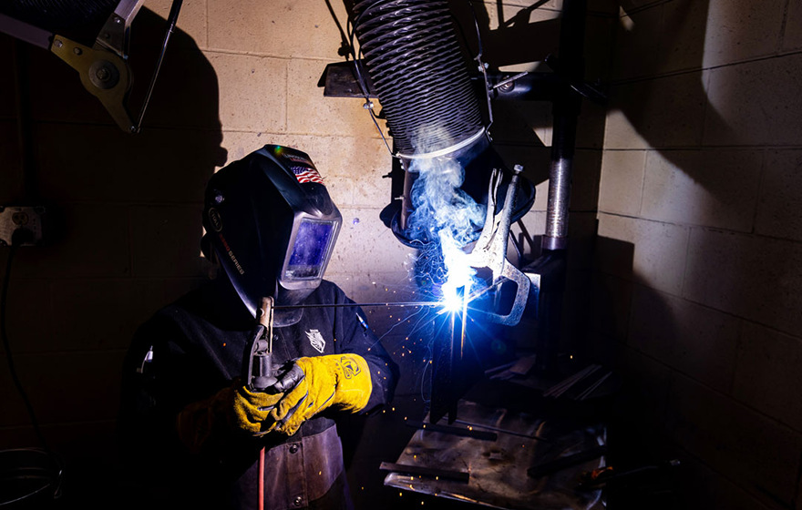 Nationally top-ranked vocational program. A student welding and sparks flying