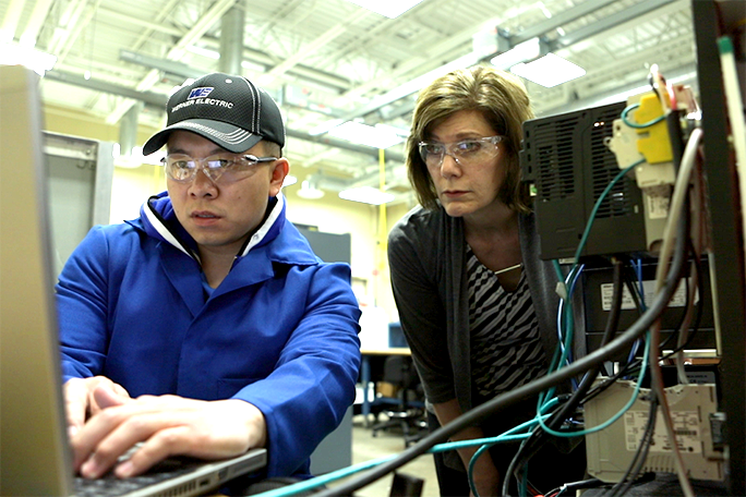 Student and instructor looking at a computer