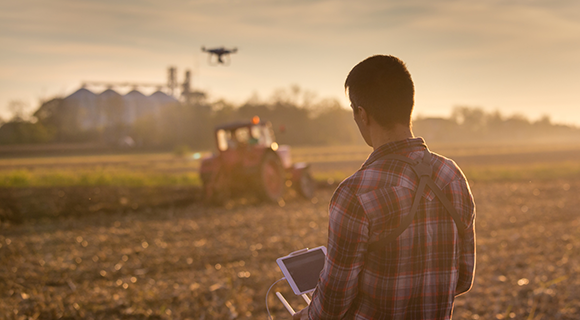 A farmer using a drone over the field