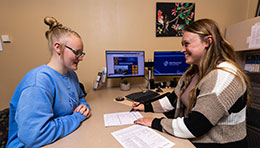 Student Services staff member assisting student in her office