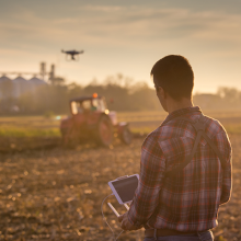 Farmer flying drone over field