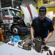 A student working on parts of a semi diesel truck