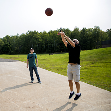 Campus Administrator playing basketball with a student